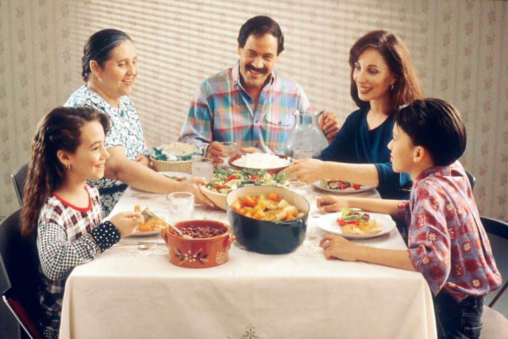 A family eating dinner together to help picky eater recipes.