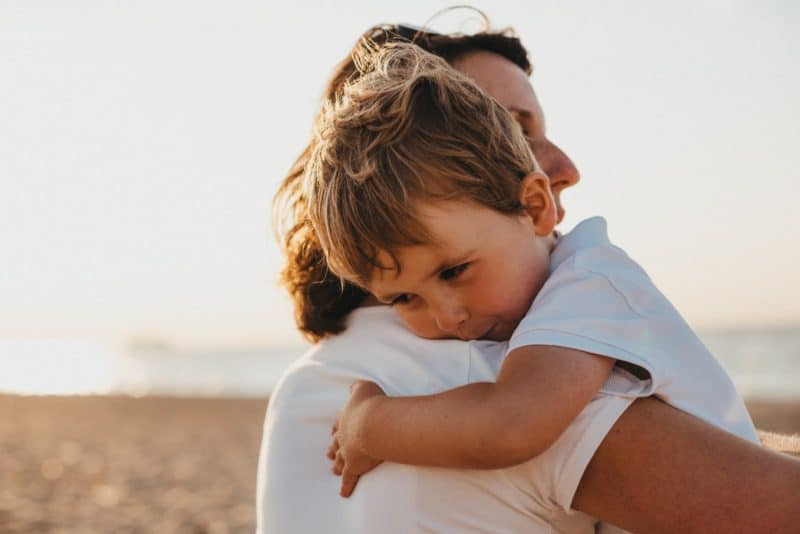 boy hugging woman during daytime living in the present