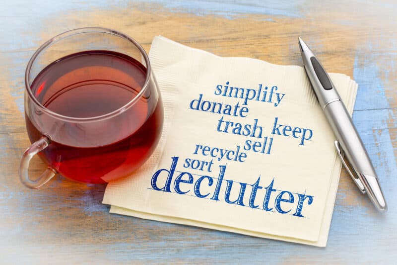Declutter challenge with an image of a cup of tea and a napkin with words (declutter, simplify, donate, trash, keep, sell, recycle, sort)