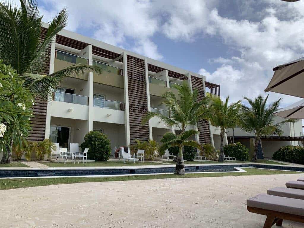 View of the Dreams Onyx hotel in Punta Cana with a pool and some palm trees.