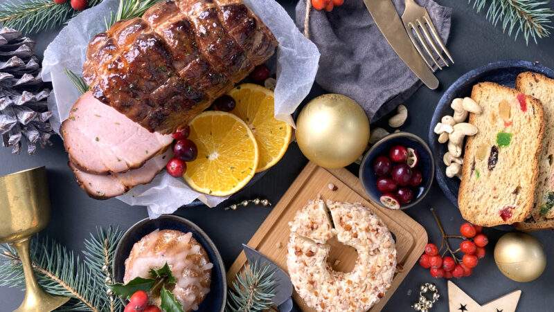 A beautiful spread of holiday food, ham, cheese, bread, fruits and more.