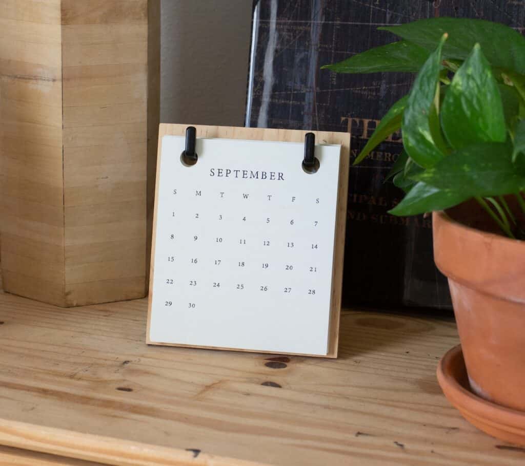 White braille paper on a brown wooden table. The calendar is cleared which is supportive to learn how to live a simple life and find happiness.