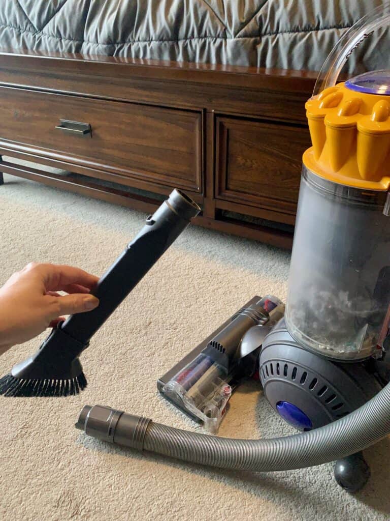 Woman showing the soft small brush adapter of her vacuum