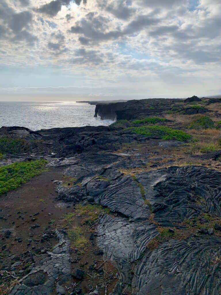 An image of an arch in the volcanic rocks by the ocean at Volcano national park.
