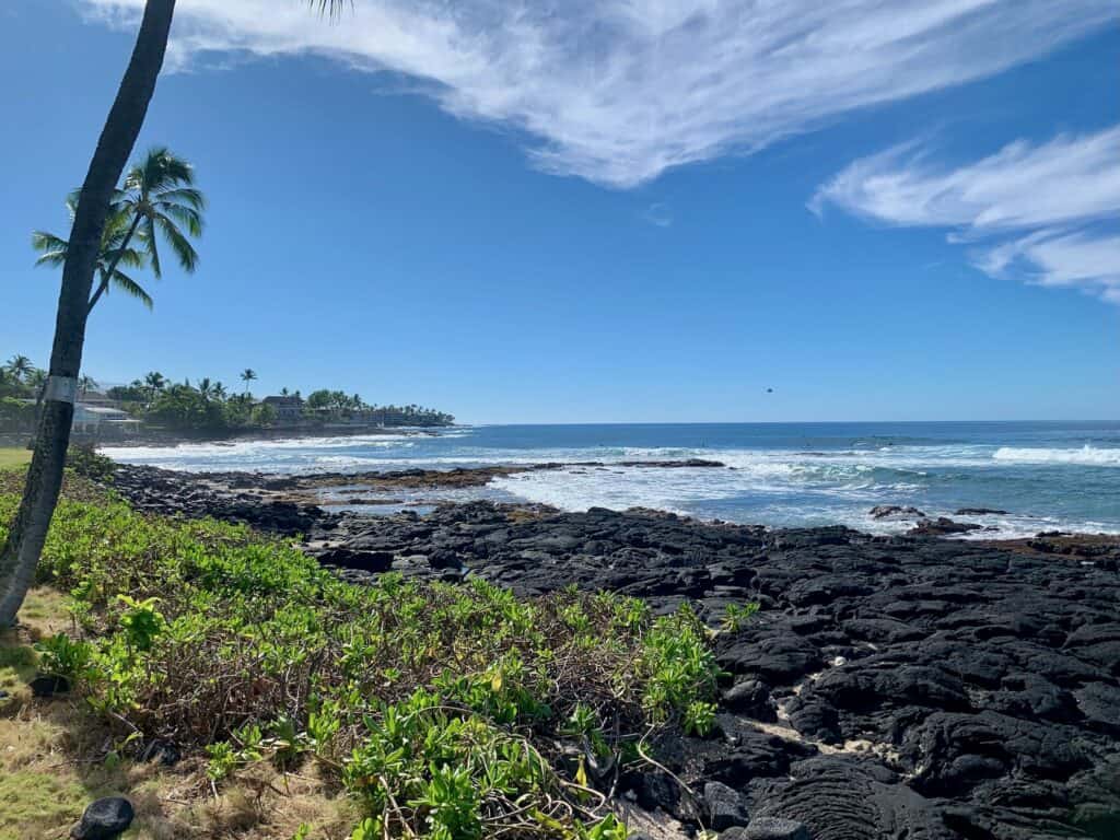 What to do on the big island ocean view. Image of a blue sky, blue ocean and black volcanic rocks.