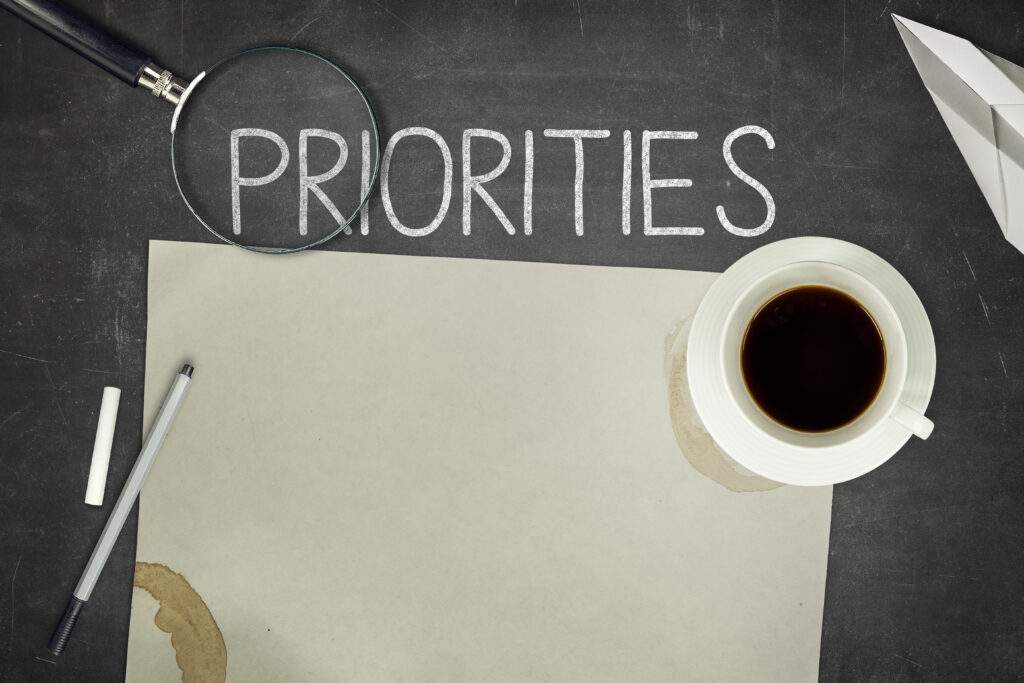 Priorities concept on black blackboard for work-life balance