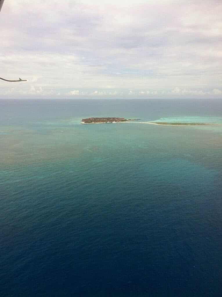 View from the sky of a blue ocean with a small island which is the Dry Tortugas.
