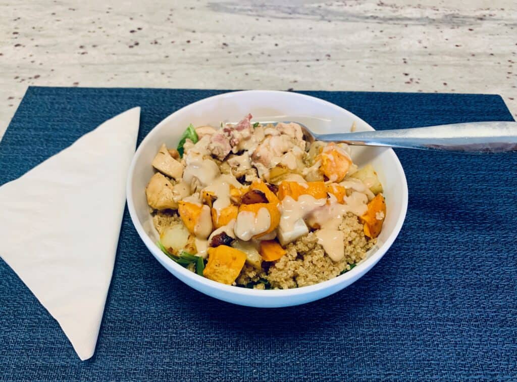 Image of a healthy quinoa bowl on top of a blue placemat with a white napkin. Best cold lunches.