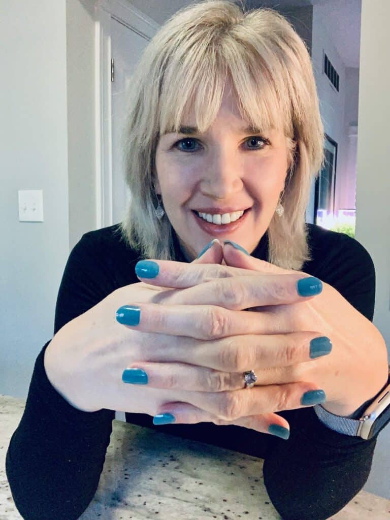 A woman showing her beautiful blue manicure
