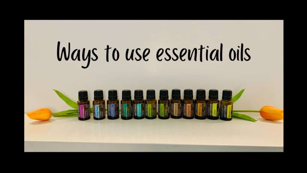 Caption saying ways to use essential oils with several bottles of essential oils and 2 orange tulips.