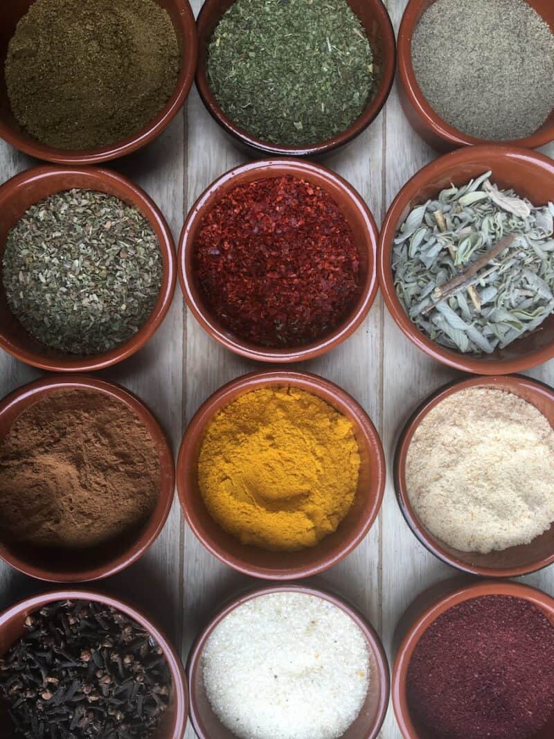 assorted spices in clear glass containers. Part of a full pantry staples list printable