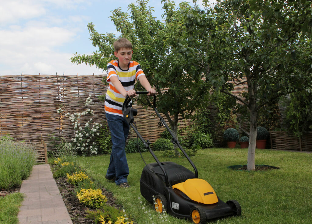 A boy mowing the lawn