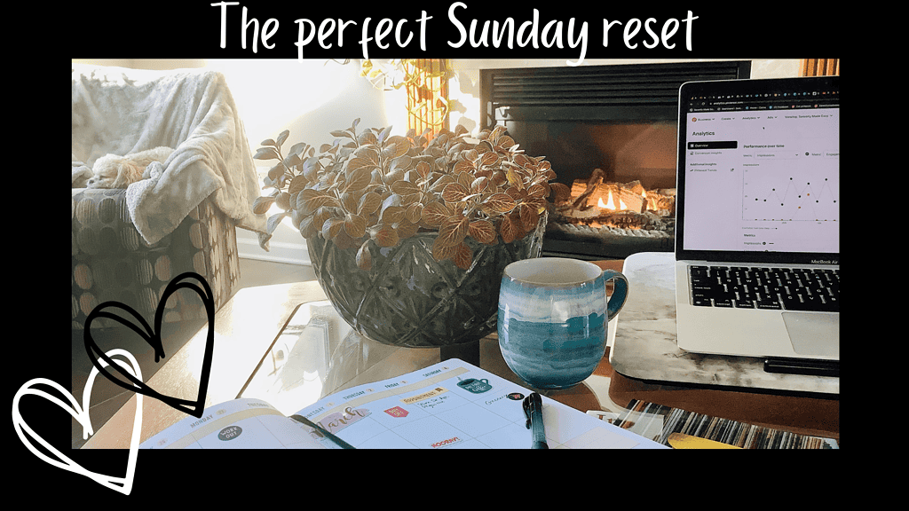 A plant, a planner, a coffee mug, a computer, a fireplace, and a dog on a chair in the background during a sunny cozy morning.