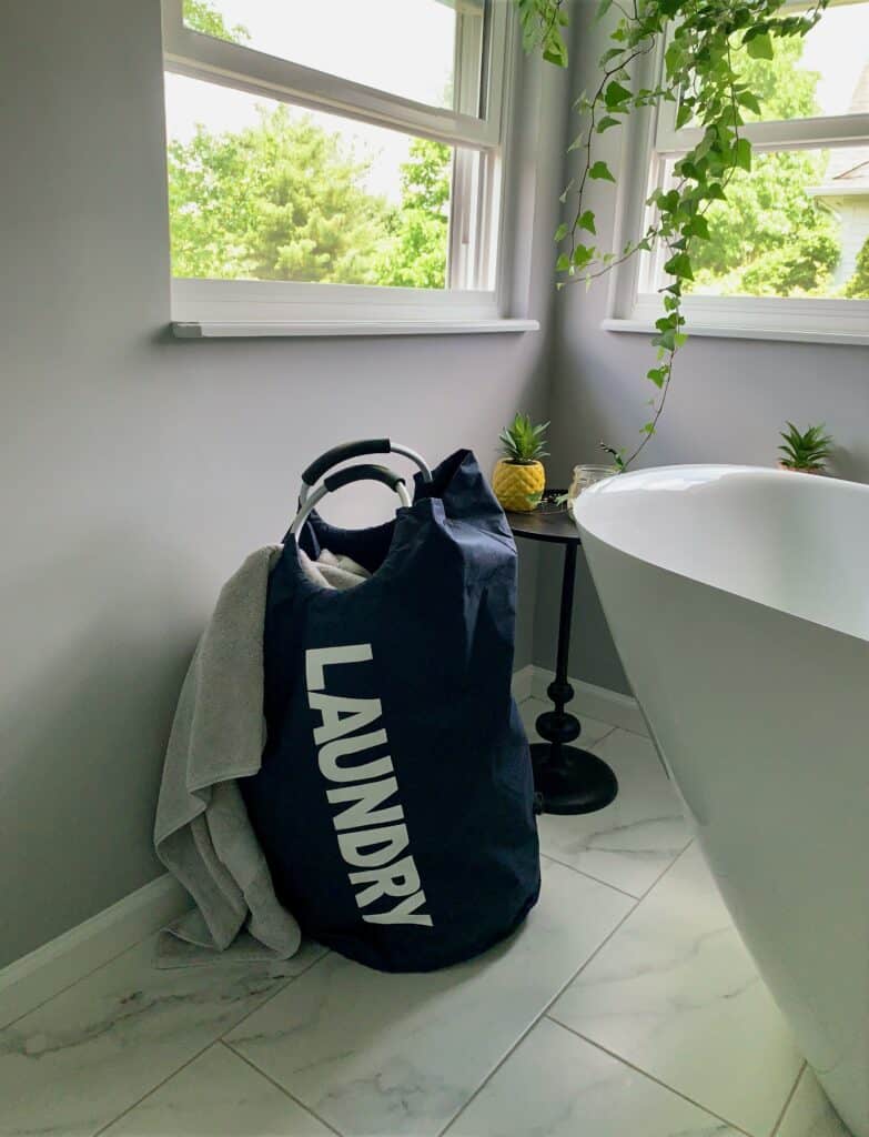 An overflowing laundry basket in a bathroom during a Sunday reset day