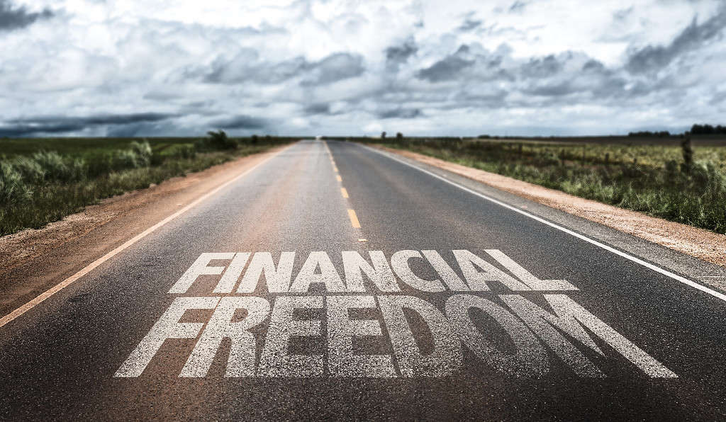 A photo of a road with words saying Financial Freedom