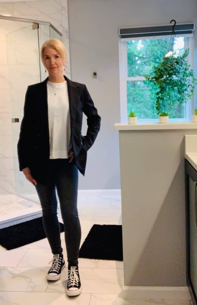 Woman wearing black skinny jeans, converse shoes, a white T-shirt and black blazer for a fun edgy fall capsule wardrobe outfit.