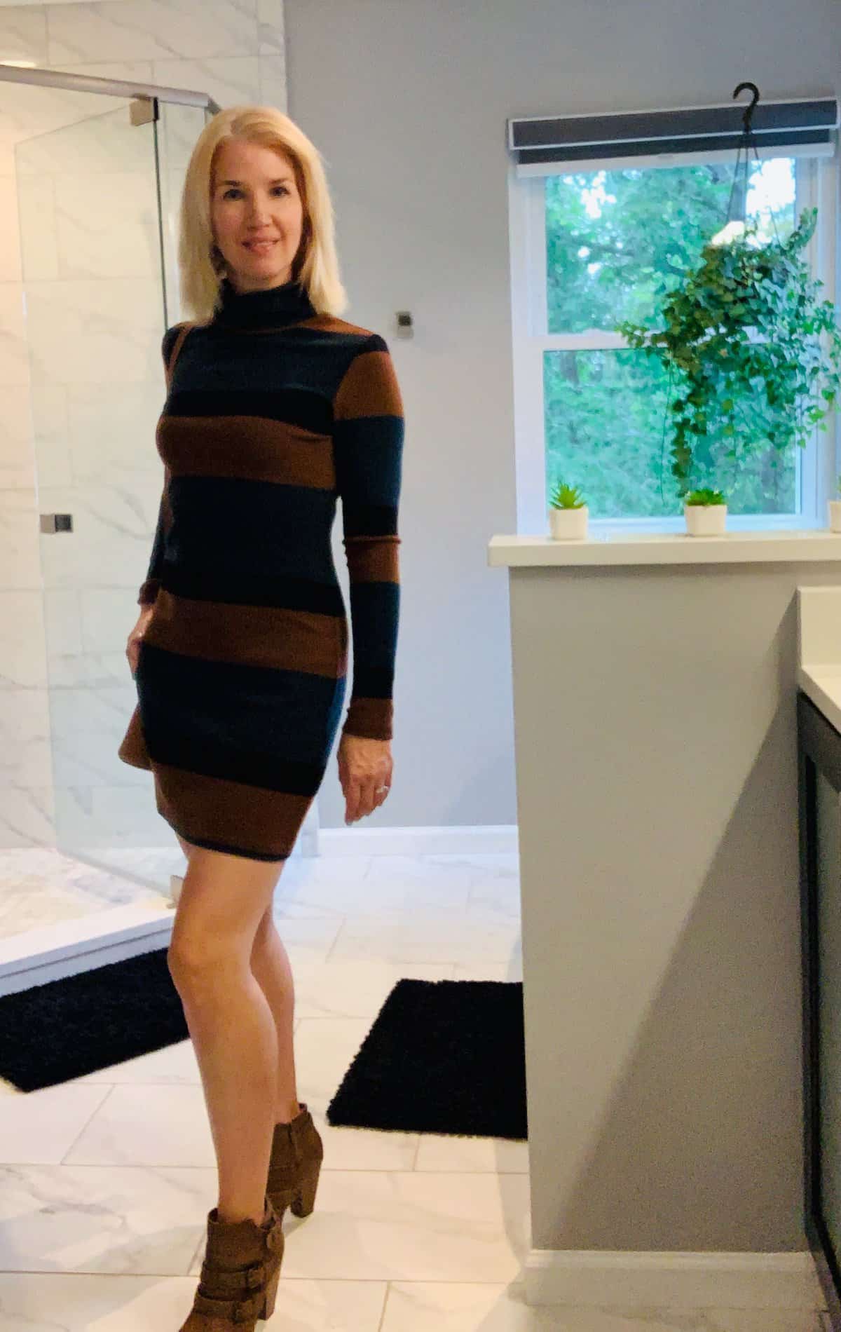 Woman wearing a sweater dress and brown booties - fall capsule wardrobe.