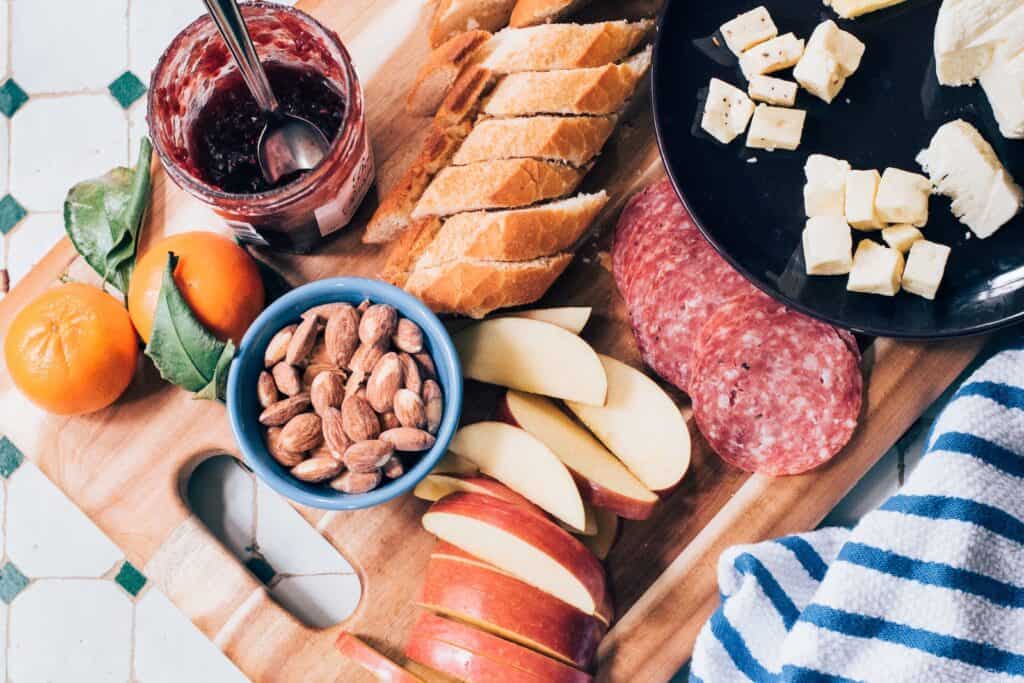 slide of apple and sausage on top of chopping board. A charcuterie inspired snack for work.