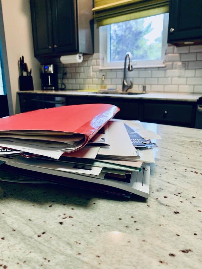 A large pile of mail to declutter in a kitchen