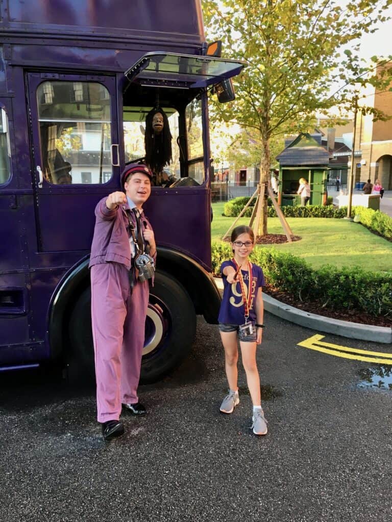A young girl with the Harry Potter night bus conductor.