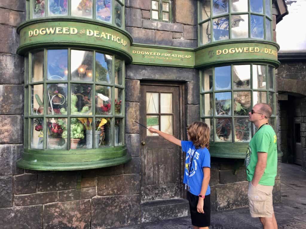 A boy casting a spell at Harry Potter world in Orlando Florida.