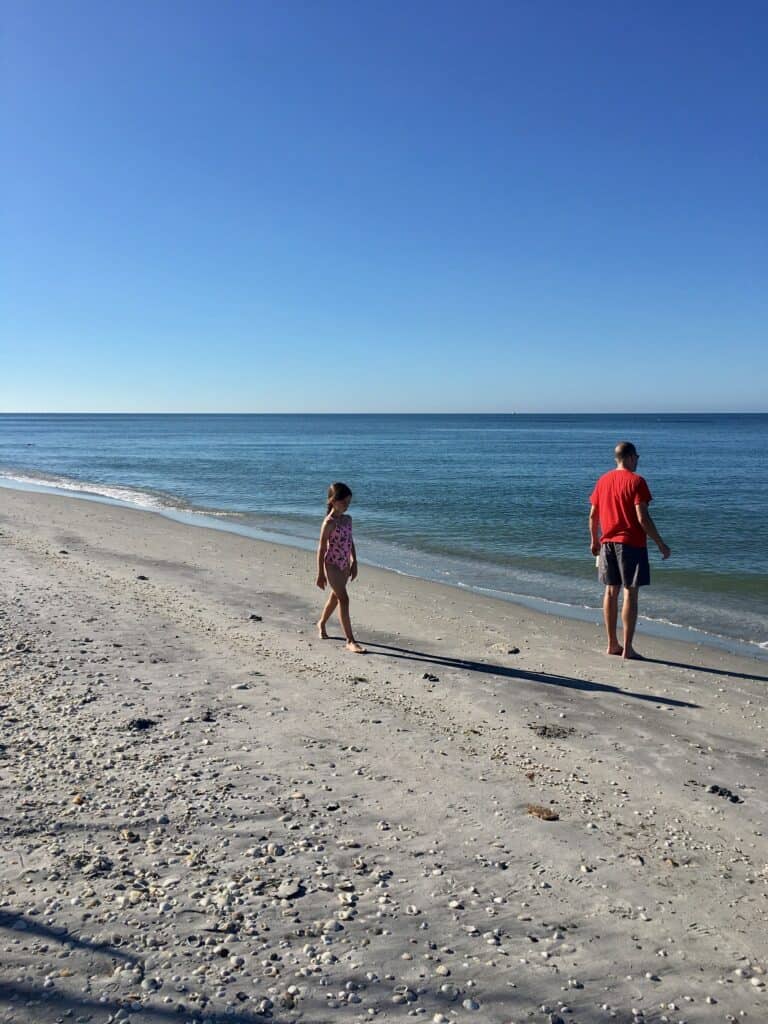 A beautiful ocean beach and blue sky, a young girl and a men during a Florida spring vacation.