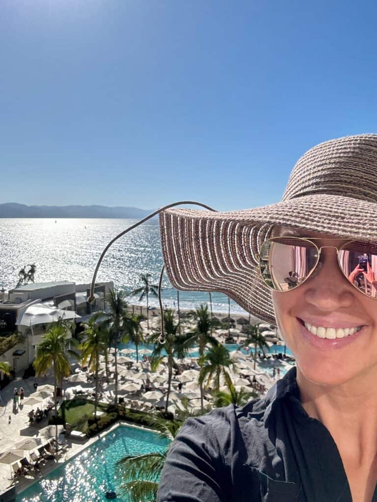 A women with the view of a resort and ocean behind