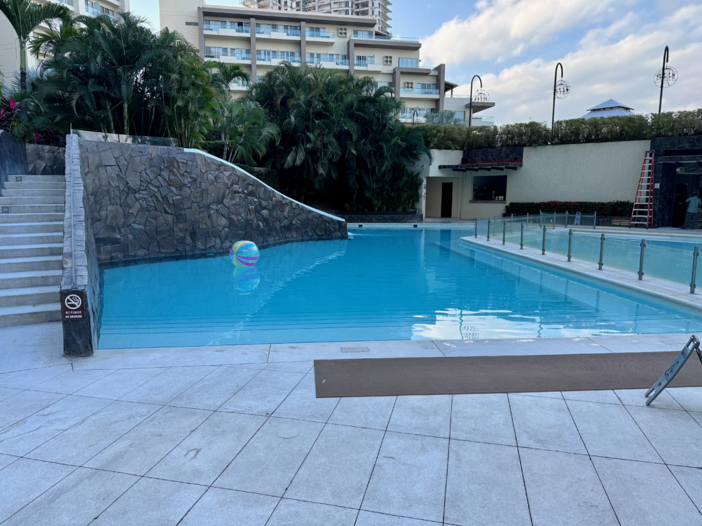 Image of a pool with stairs going up to a small slide