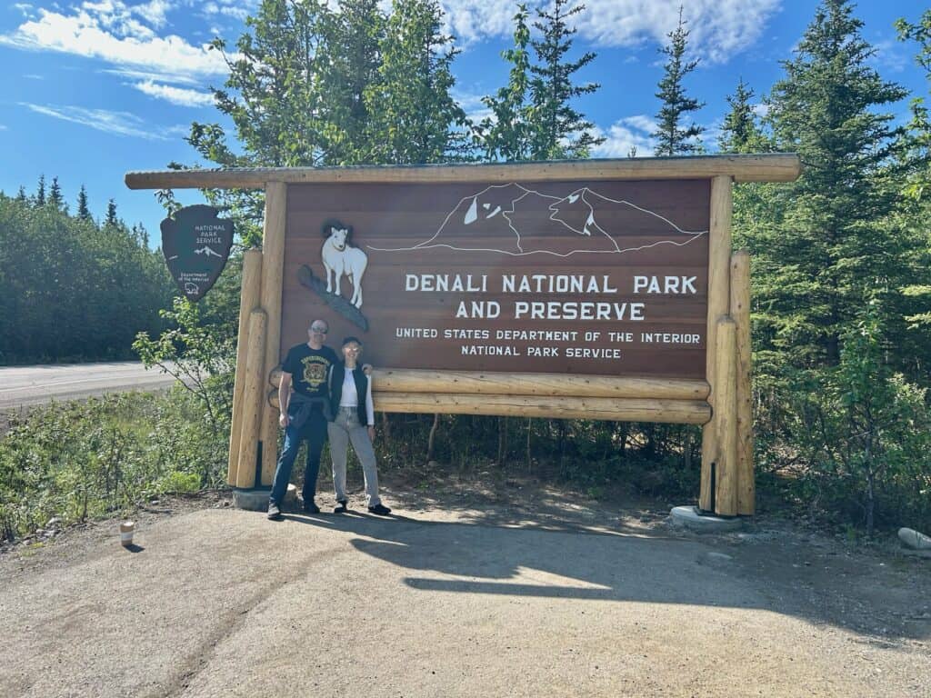 Couple with Denali National Park wooden sign